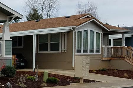 Manufactured home with a big bay window in a manufactured home community in Texas.